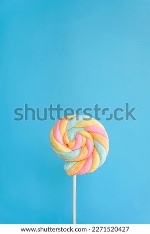 Rainbow twist roll marshmallow like lollipop on blue background  Royalty-Free Stock Photo #2271520427
