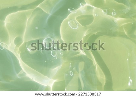 The texture of a green gel or serum with hyaluronic acid for the face. Cosmetic transparent liquid cream with oxygen bubbles. Wellness and beauty concept. Sanitizer, virus protection. Soft focus. Royalty-Free Stock Photo #2271538317