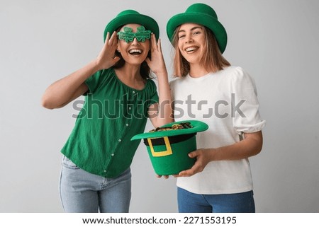 Young women with leprechaun's hat on light background. St. Patrick's Day celebration