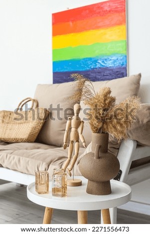 Vase with pampas grass and mannequin on table in living room