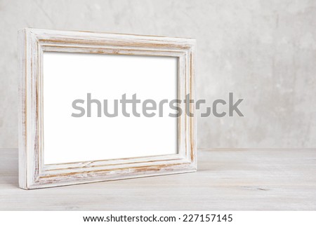 Old painted photo frame on table over abstract background