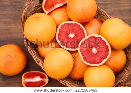Wicker basket with fresh grapefruits on wooden table, flat lay Royalty-Free Stock Photo #2271585463