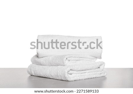 Soft terry towels on light table against white background