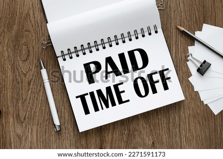 Paid time off symbol. open notepad with text. wooden background. Business, paid time off concept, copy space. Royalty-Free Stock Photo #2271591173