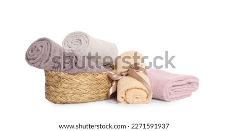 Wicker basket and rolled bath towels on white background