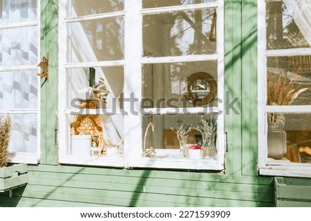 porch of a rustic wooden village house in white and green color, concept of a simple country life