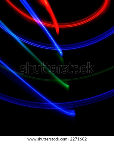 Strong forms of fast moving colorful lights against black background.