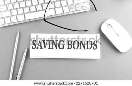 SAVING BONDS text on a paper with keyboard on grey background