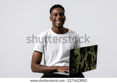 Happy african ameircan trader buisnessman programmer student with new modern laptop in hands standing over grey background in studio isolated working studying smiling looking at camera.