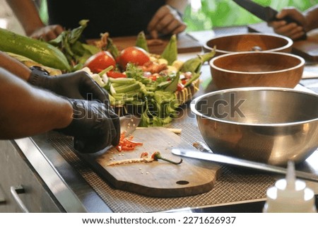 Adult students learning recipe and preparing meal in cooking class Royalty-Free Stock Photo #2271626937