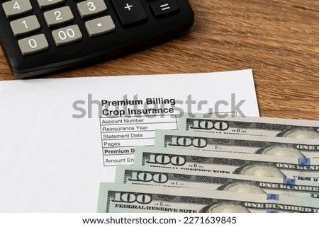 Crop insurance premium bill with cash money. Concept of grain yield loss, hail and wind field damage and farm income protection. Royalty-Free Stock Photo #2271639845