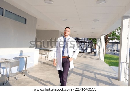 Male doctor in medical gown standing at hospital.