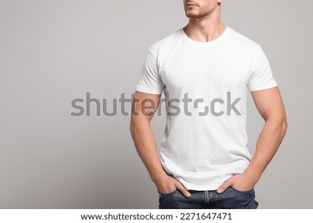 Man wearing white t-shirt on light grey background, closeup. Mockup for design Royalty-Free Stock Photo #2271647471
