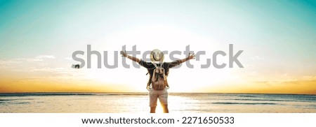 Back view of happy excited man raising arms up to blue sky - Hipster winner traveler enjoying summer sunset at the beach - Travel, mental health, success, business, tourism and life style concept Royalty-Free Stock Photo #2271650533