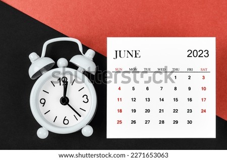 June 2023 Monthly calendar year with alarm clock on red and black background. Royalty-Free Stock Photo #2271653063