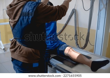 A radiologist adjusts the position of the x-ray generator to accurately take a knee x-ray at the hospital radiology room. Royalty-Free Stock Photo #2271655905