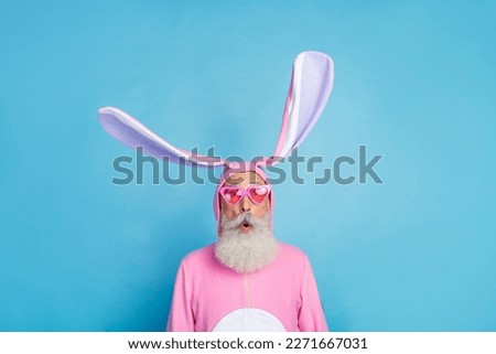 Portrait of funky astonished positive elderly pensioner wear pink bunny costume impressed staring isolated on blue color background Royalty-Free Stock Photo #2271667031