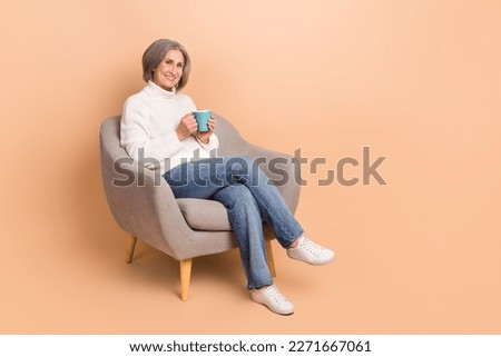 Full length photo of sweet shiny woman wear knitted pullover drinking tea empty space isolated beige color background