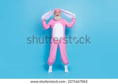 Full length photo of astonished man dressed pink rabbit costume arms hold ears impressed staring isolated on blue color background