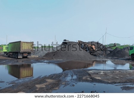 puddles of rainwater in coal stockpile Royalty-Free Stock Photo #2271668045
