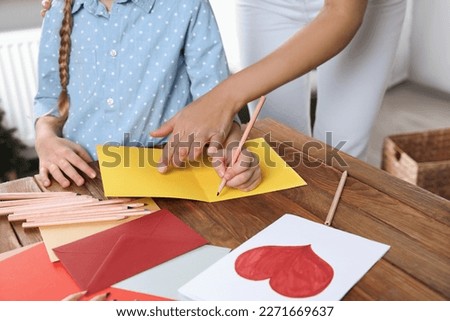 Little girl with her mother making beautiful greeting card at home, closeup Royalty-Free Stock Photo #2271669637