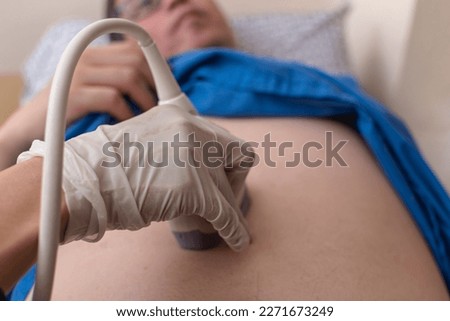 An abdominal ultrasound procedure on a male patient. Checking for bowel, kidney, liver or intestinal disease, and other organs in the abdominal cavity. Royalty-Free Stock Photo #2271673249