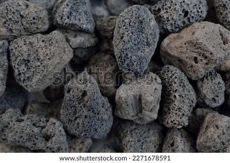 Porous black volcanic rock isolated on white background. Lava stone, pumice stone, or volcanic pumice with distinctive pores. Royalty-Free Stock Photo #2271678591