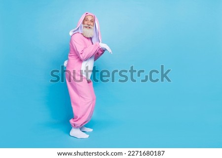 Side profile full size photo of optimistic overjoyed funny elderly pensioner wear pink bunny costume isolated on blue color background