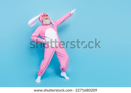 Full length photo of charming funky man pensioner dressed pink rabbit nightwear heart eyewear empty space isolated blue color background