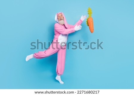 Full body photo of cheerful aged person arms catch falling big carrot isolated on blue color background