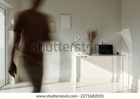 Businessman leaving minimalistic style office, blurred motion