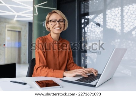 Portrait of happy and successful female programmer inside office at workplace, worker smiling and looking at camera with laptop blonde businesswoman is satisfied with results of achievements at work Royalty-Free Stock Photo #2271691093