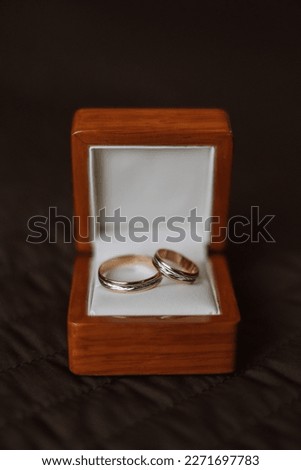 Close-Up Of Wedding Rings In Box On Table. wedding rings. Two golden wedding rings in a wooden box on a soft pillow.