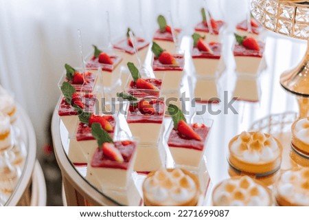 Candy bar. Table with sweets, candies, dessert. cakes and berries in the candy bar. Candy bar with delicious mini cakes, selective focus Royalty-Free Stock Photo #2271699087