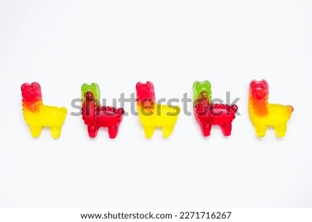 Jelly marmalade candies in the form of llamas on a white background. Colorful sweet confectionery on an isolated white background. Multicolored jelly candies lined up in a row