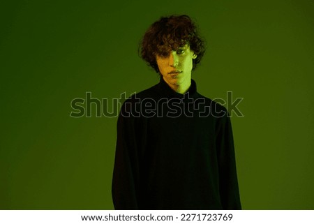 Man fashion and style accessories model with curly hair, stylish hairstyle, hipster dance teen lifestyle, portrait green background mixed neon light, copy space