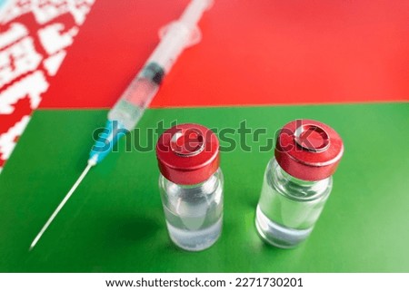 Pharmacology and Medicine belarus concept. vaccine against coronavirus covid. Vaccine ampoules, syringe against the background of national flag. national pharmacological industry.
