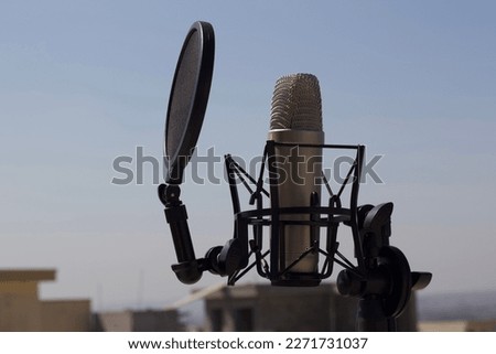 A condensor microphone in open nature. Condensor microphone next to Sky. 