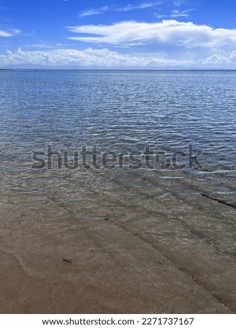 A picture of a calm sea and its waters, clear sea and sand
