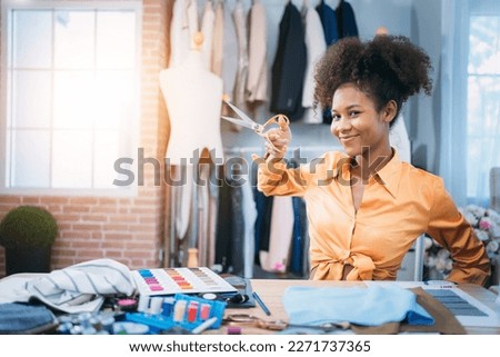 Portrait of fashion designer working in clothes in tailoring atelier. Tailor woman with fabric and clothing sketches at the office. fashion designs and handmade Concept