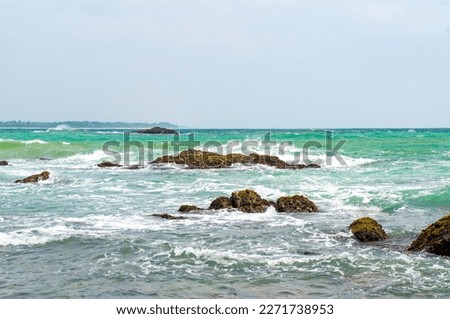 Beautiful tropical landscape. A stone ocean shore with waves and rocks. Beautiful texture background for tourism, design and advertising
