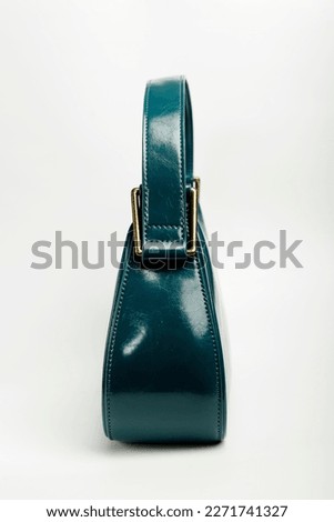 side photo of green woman's handbag on white background