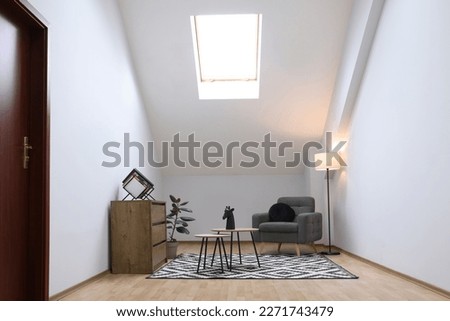 Attic room interior with slanted ceiling and furniture Royalty-Free Stock Photo #2271743479