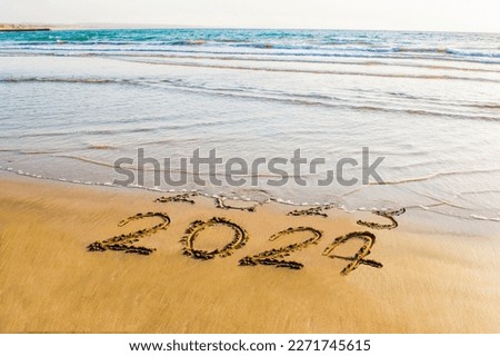 happy new year 2024 text on sea beach. Abstract background photo of coming New Year 2024 and leaving year of 2023