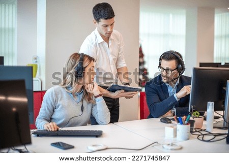 Young handsome supervisor bringing and showing performance review to his employees at call center. Royalty-Free Stock Photo #2271745847