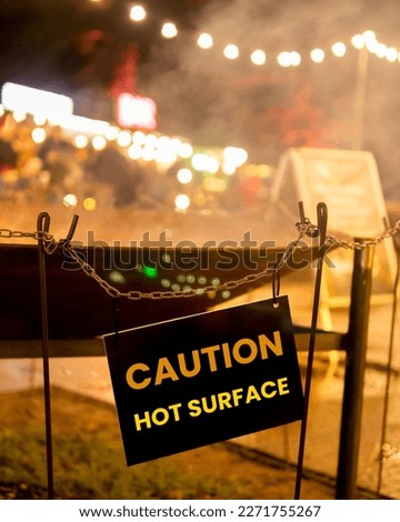 Notice on a hot smoking cauldron saying, Caution Hot Surface