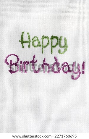 The inscription "Happy Birthday" is embroidered on a white fabric.