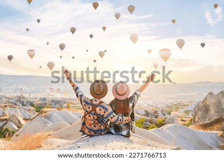 Traveling couple with open arms hugging together and make wish in scenic valley in Anatolia, Kapadokya. Beautiful destination in Nevsehir, Goreme Royalty-Free Stock Photo #2271766713