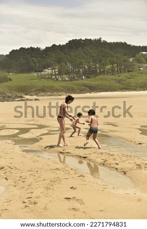 caucasian family plays in the sand on the beach