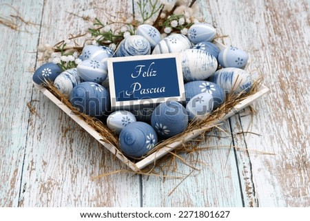 Nest with blue and white Easter eggs. Spanish inscription means Great Easter.